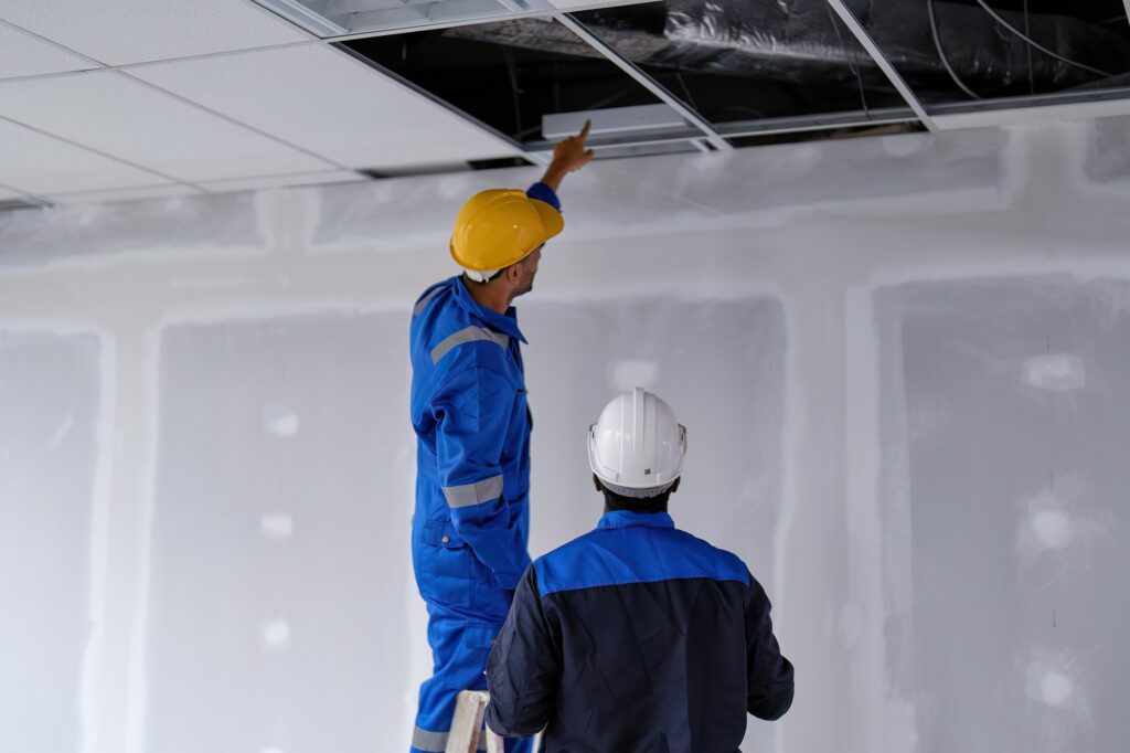 At new construction building worker open ceiling to check air condition duct on the top